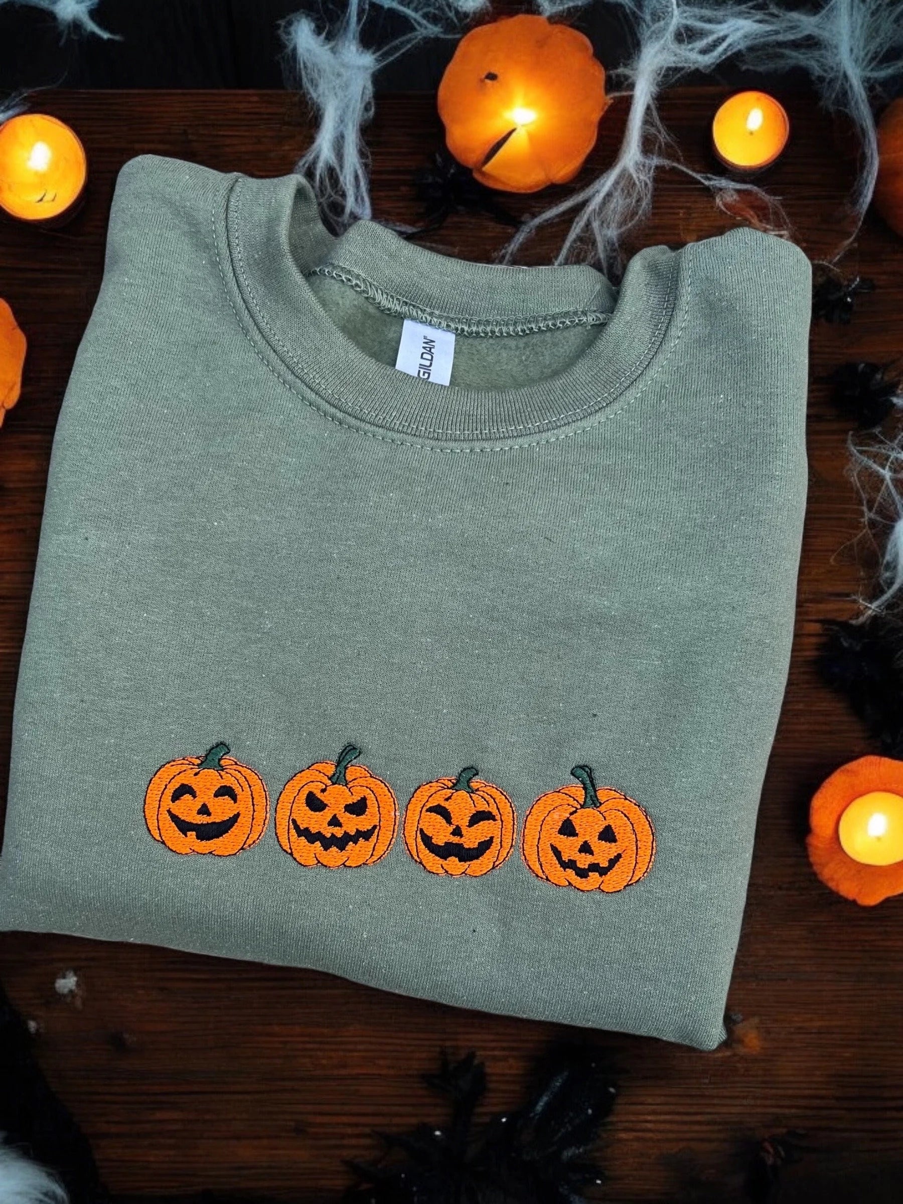 sweatshirt with embroidered Halloween-themed pumpkin designspider webs.