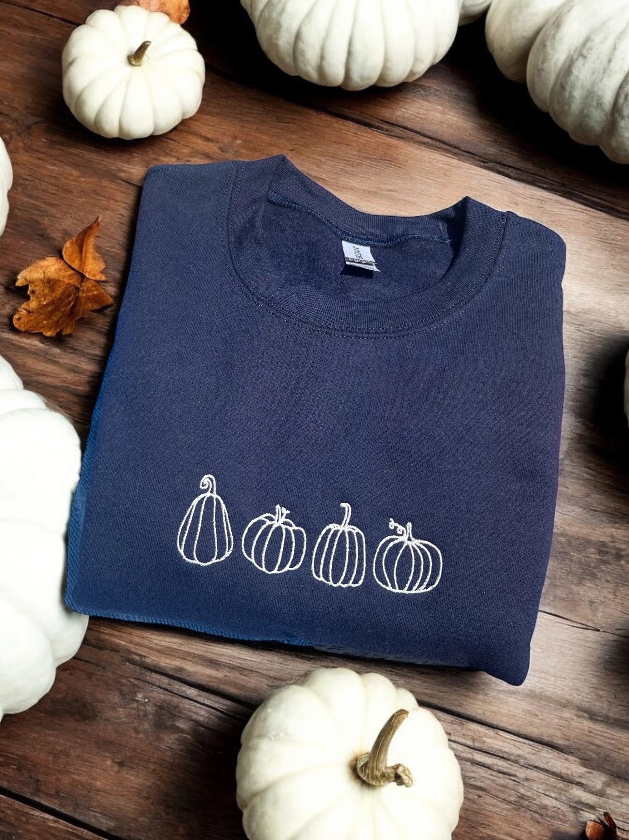 navy blue sweatshirt with embroidered white pumpkins