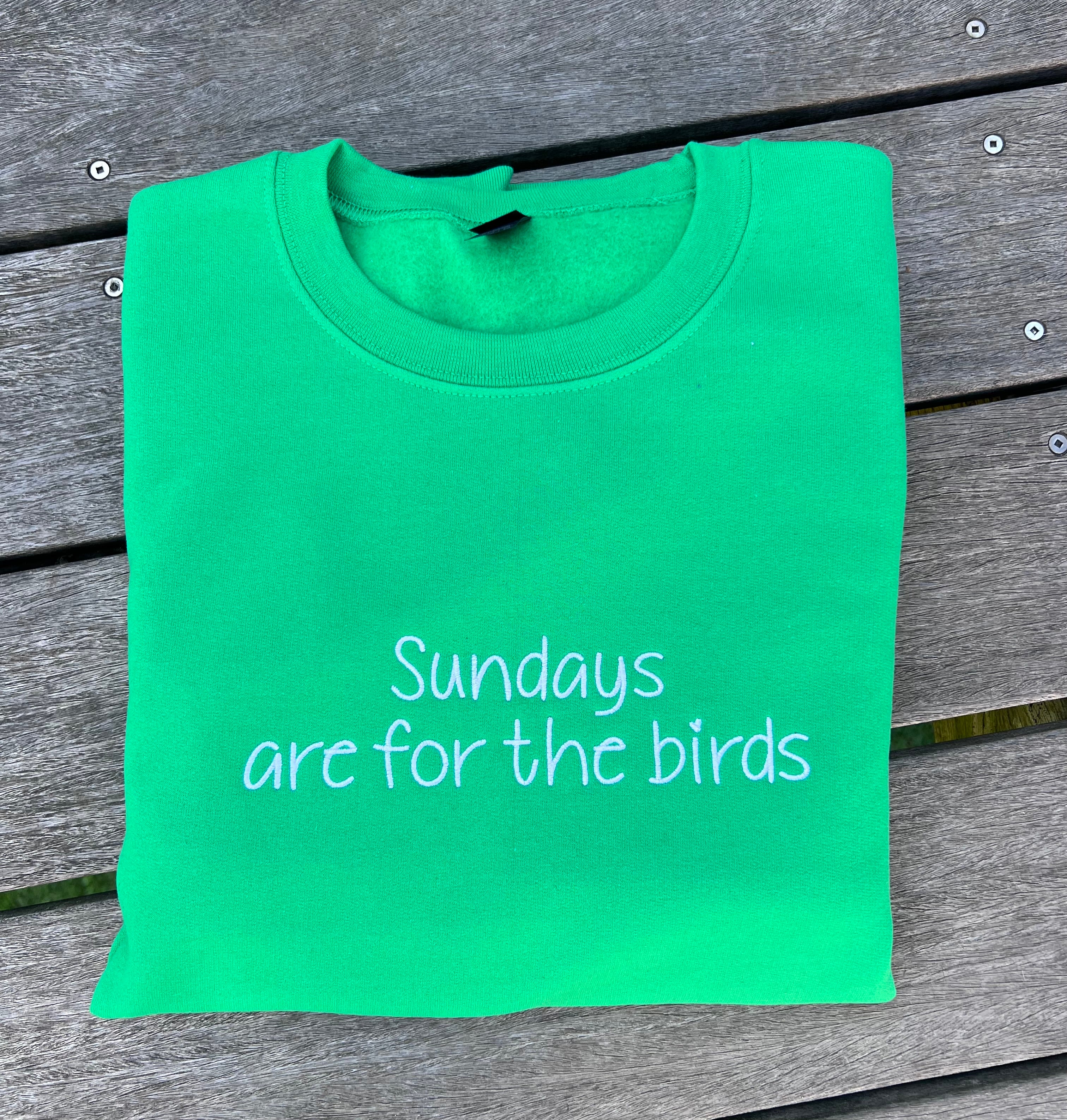 green sweatshirt with sundays are for the birds embroidered on it