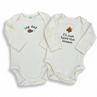 Two white baby onesies with humorous text and graphics on a white background
