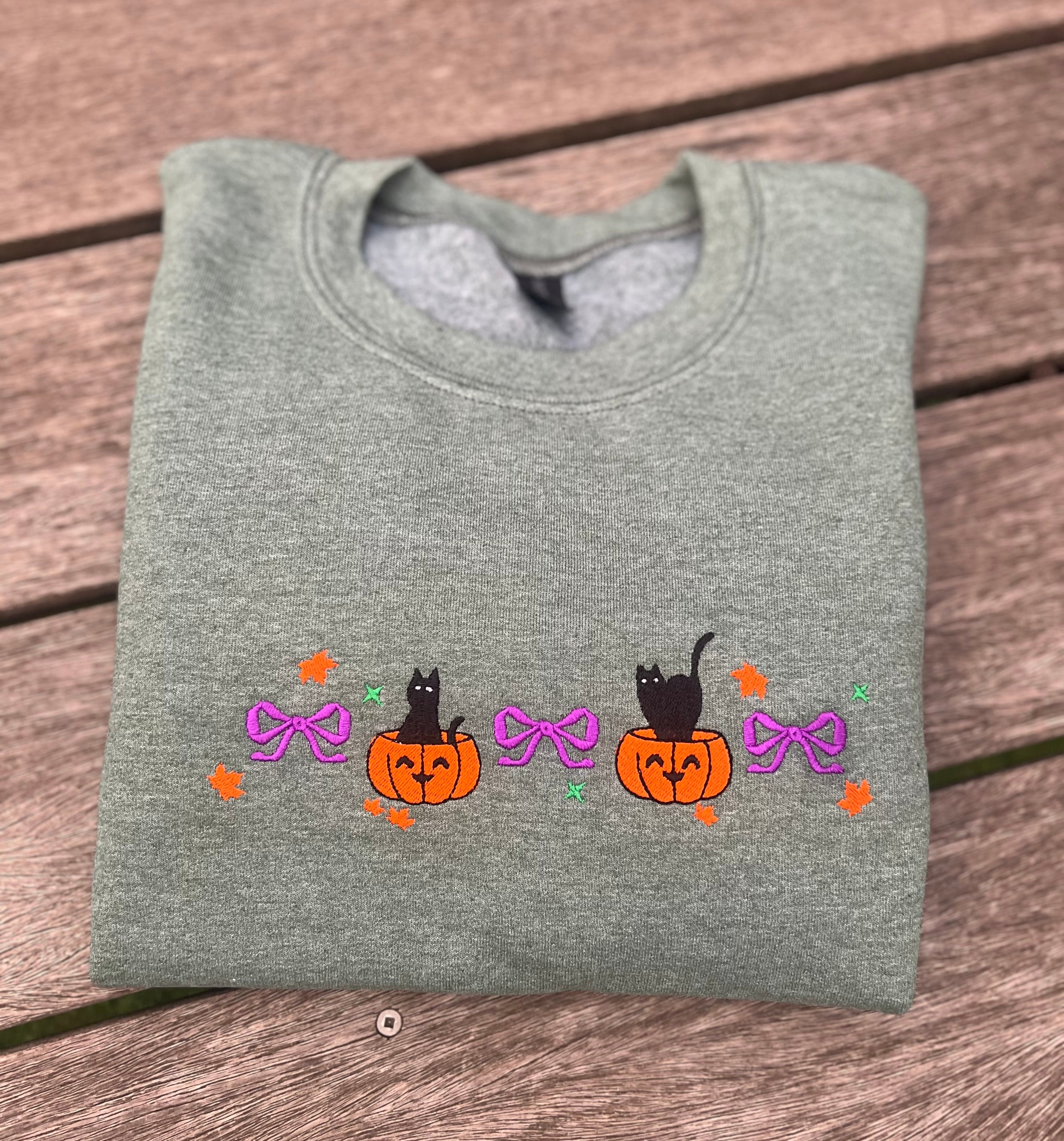 green sweatshirt with embroidered cat and pumpkins with bows
