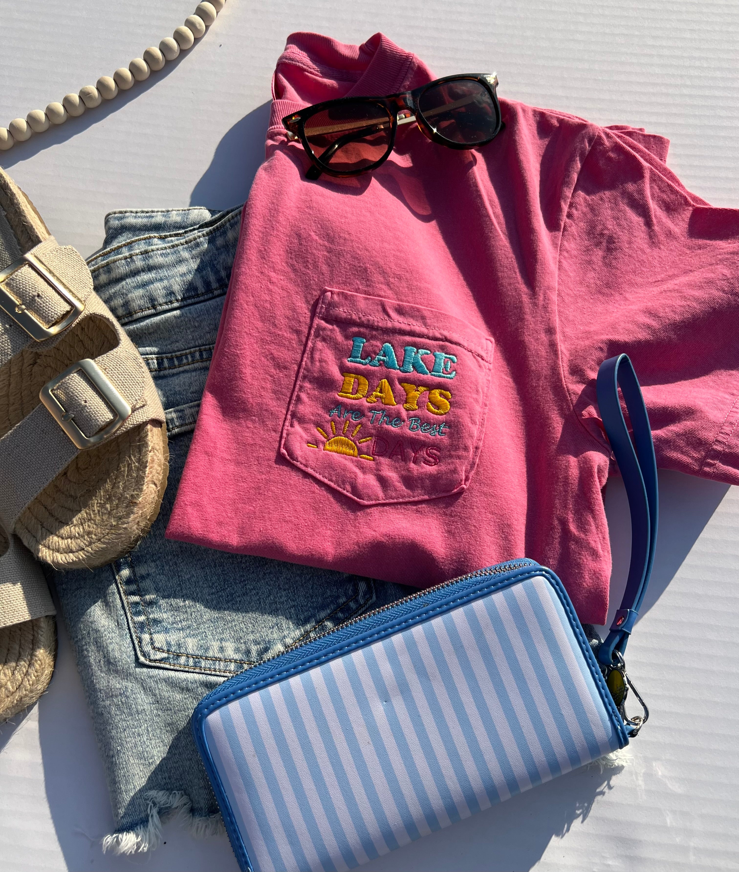 bright pink t0shirt with a pocket with embroiderery that says lake days are the best days