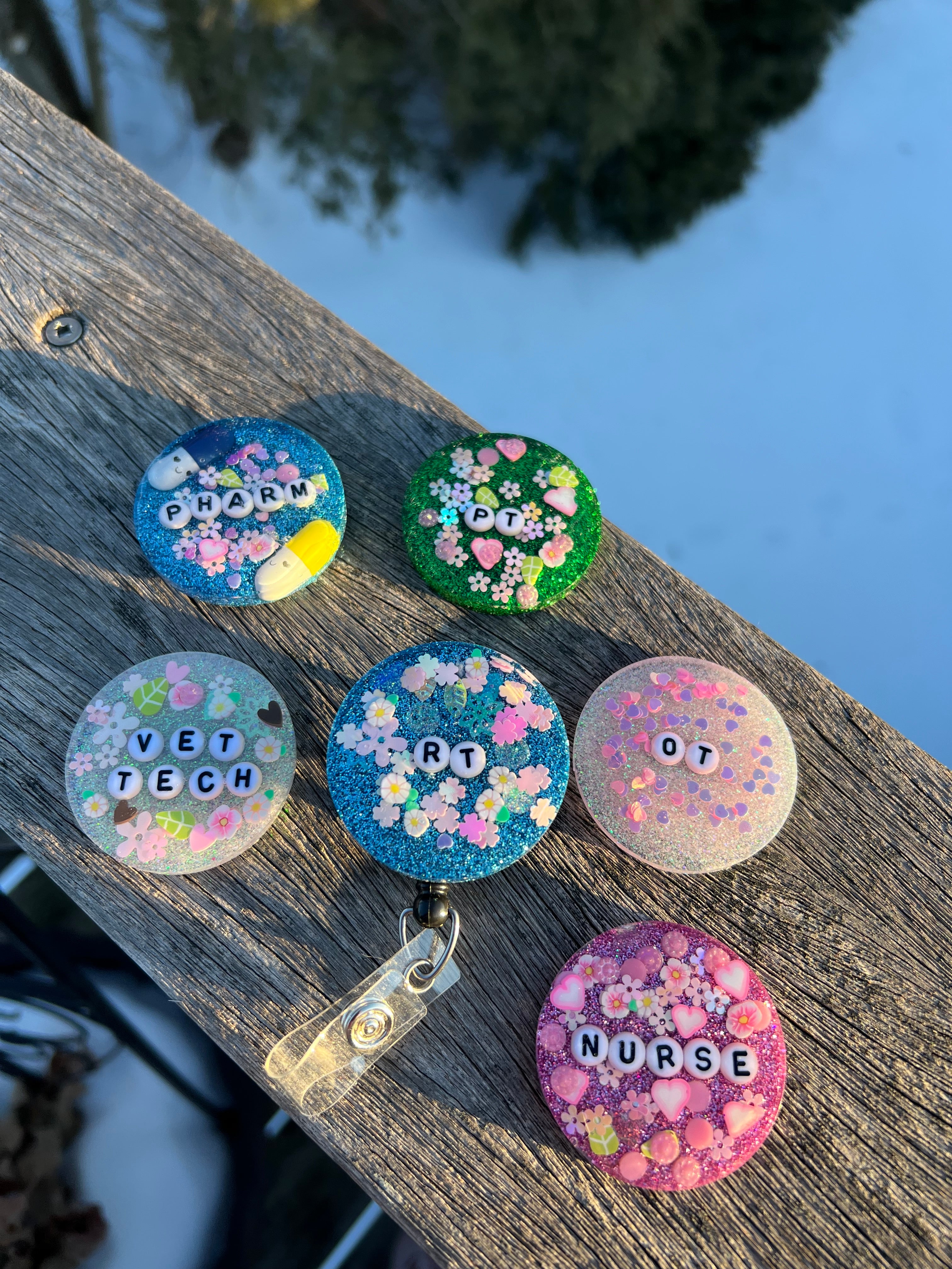 Colorful badge reels with various designs on a wooden surface