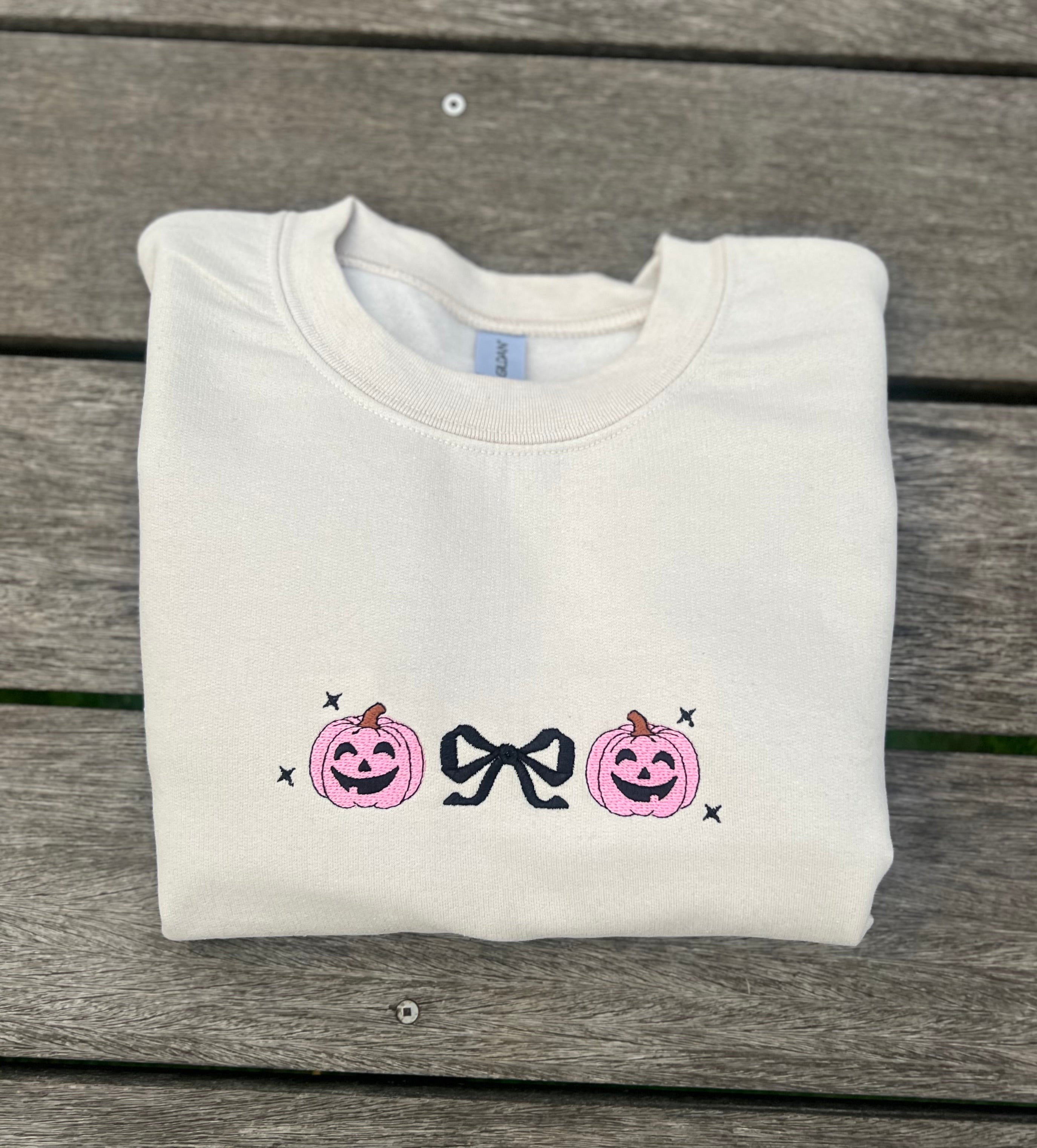 neutral colors embroidered sweatshirt with pink jack o lanterns and black bow