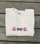 neutral colors embroidered sweatshirt with pink jack o lanterns and black bow