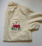 Beige shirt with a pocket featuring embroidered flamingo design onthe pocket