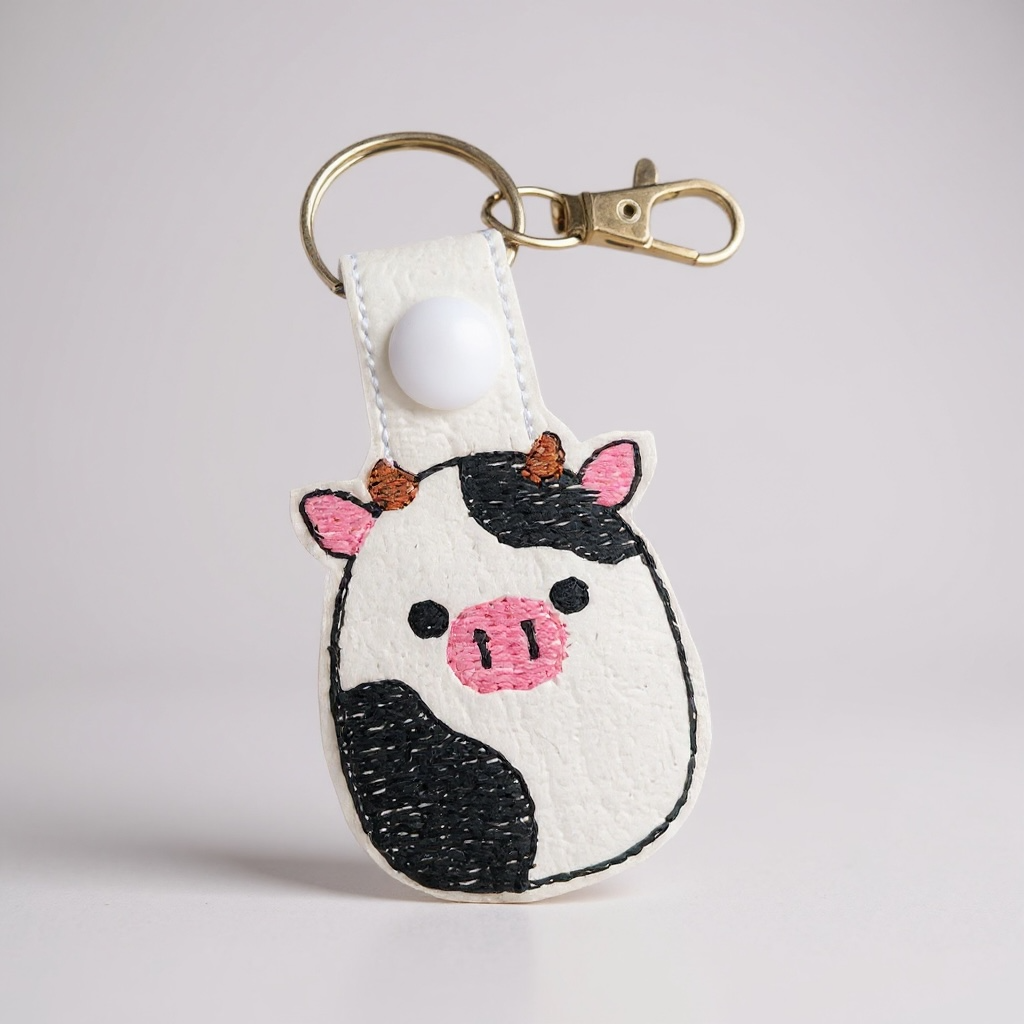 Cow-shaped keychain with a white background