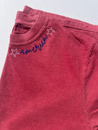 Red sweatshirt with 'america' text and star designs on a light gray background