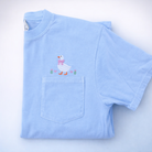 Light blue t-shirt with a goose and flowers embroidered above a pocket